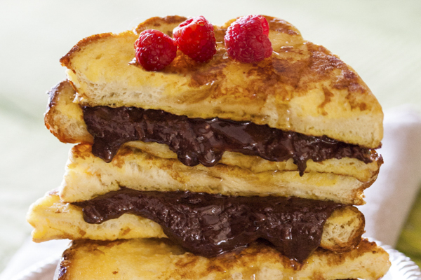 a stack of chocolate hazelnut french toast topped with raspberries