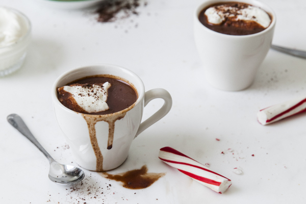 two mugs of hot chocolate with broken peppermint sticks
