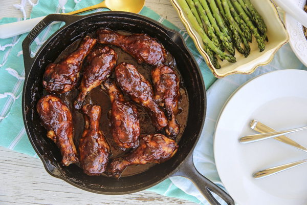 chicken drumsticks in a cast iron skillet with chocolate bbq sauce on top